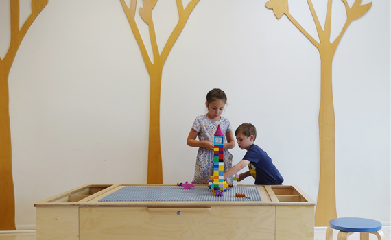 Children playing at a Lego table